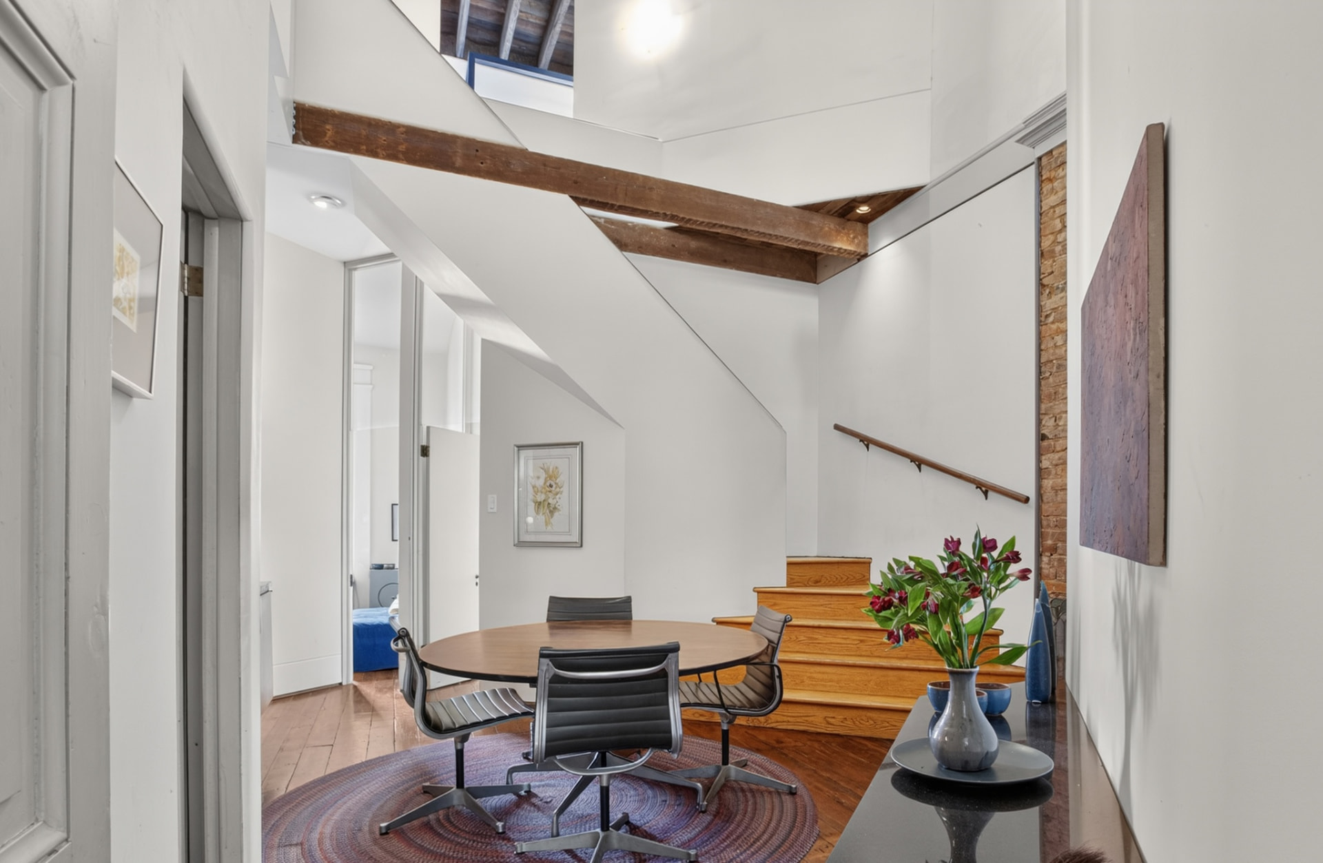 Dining area beneath a hand hewn beam within the architect's atrium