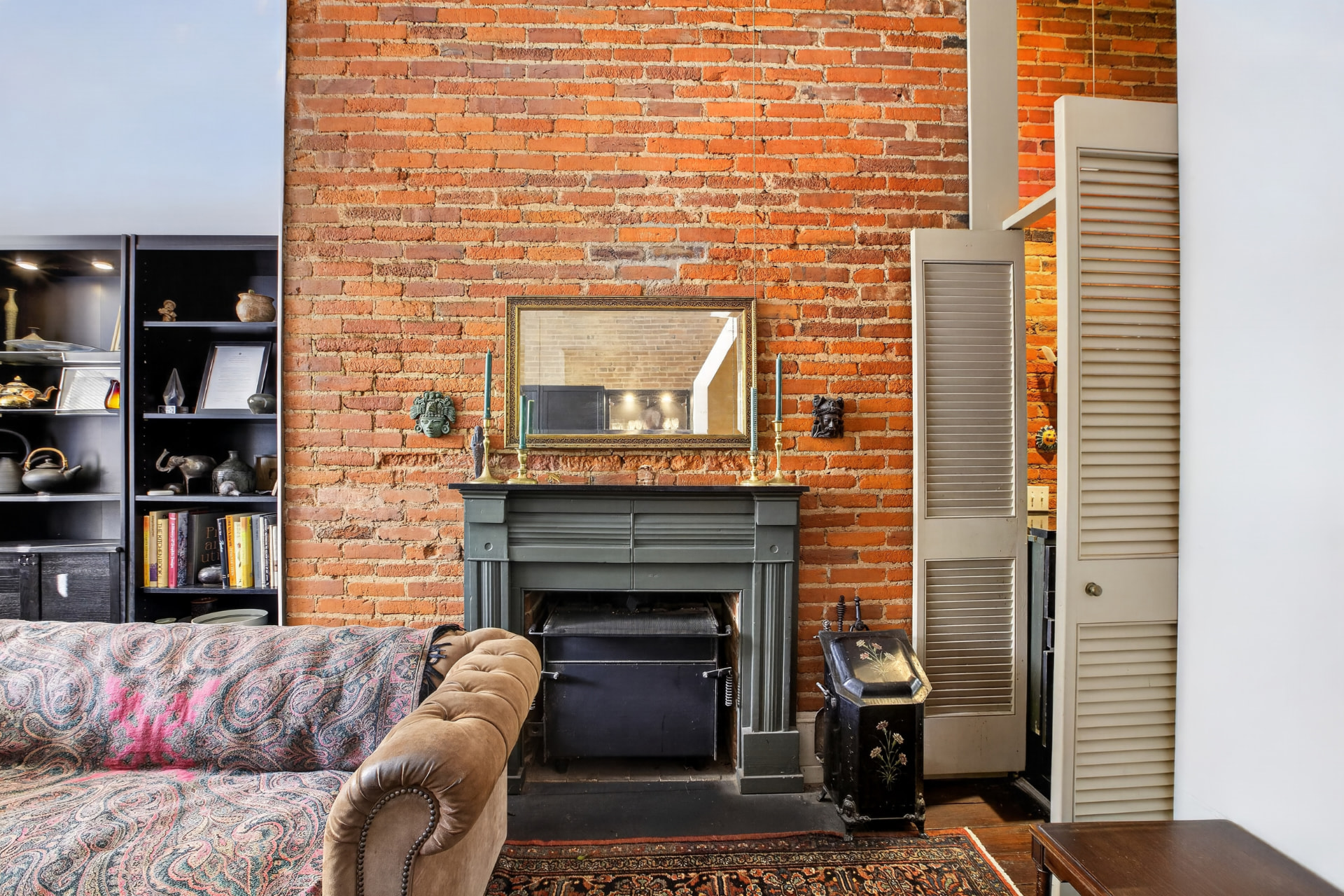 Living room with full height exposed brick chimney breast and period mantel