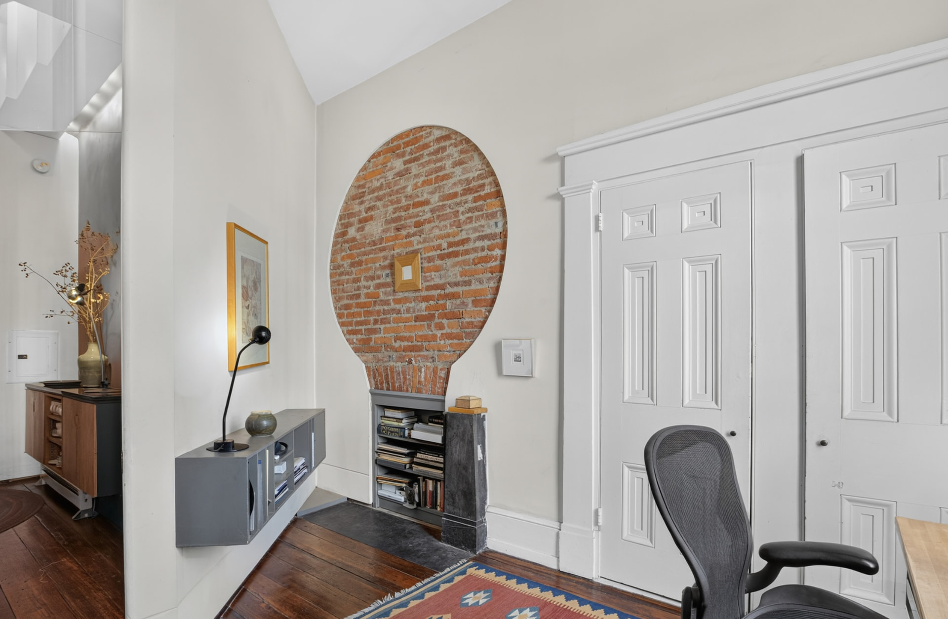 Study with oval opening revealing original brick above a slate hearth