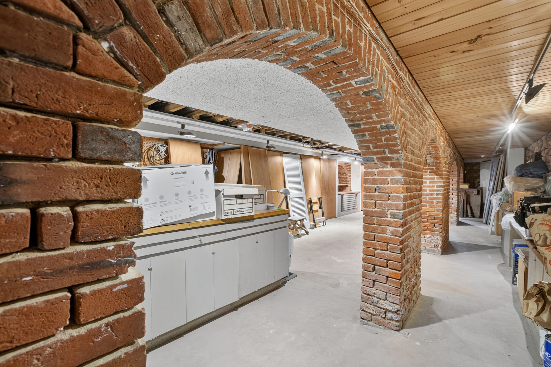 Brick vaulted lower level with a run of exposed arches and a workshop bench